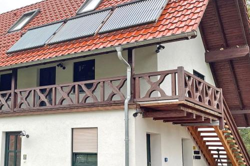 a deck on the side of a house with a roof at Baumhaus Baum 4 in Burg