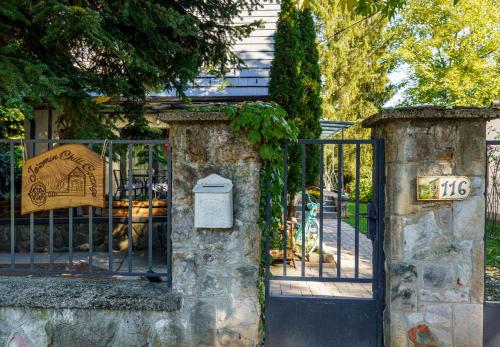 a gate to a house with a sign on it at Jázmin Chill Cottage in Bánk