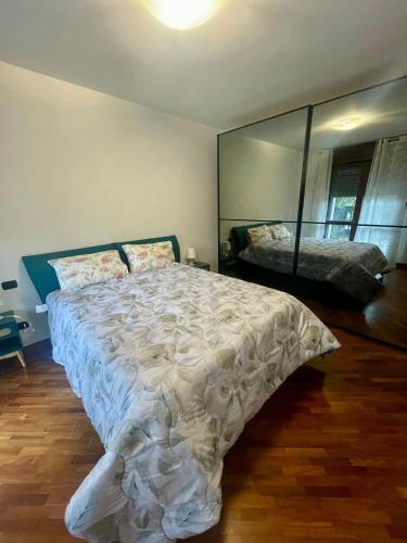 ein Schlafzimmer mit einem großen Bett und einem Spiegel in der Unterkunft la corte in Vimodrone