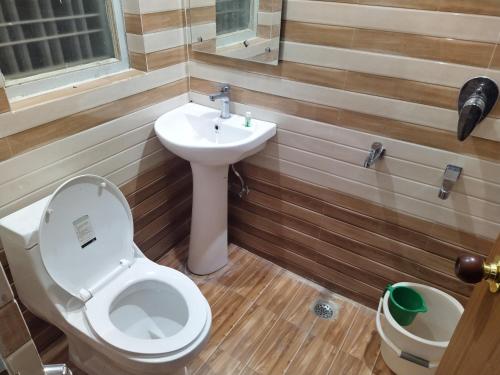 a bathroom with a toilet and a sink at The pine view Orchard homestay in Rāmgarh