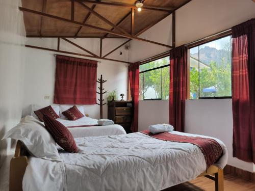 a bedroom with two beds and a large window at The Willow B&B in Urubamba