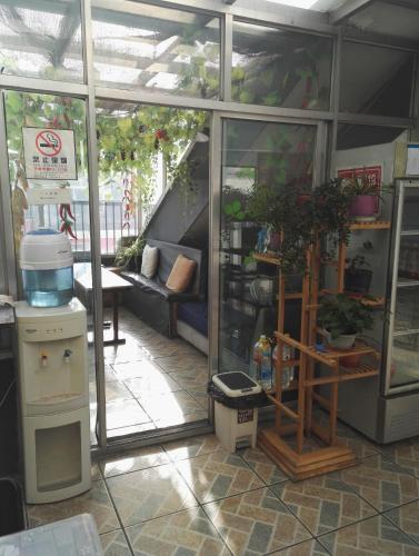 a greenhouse with glass doors and plants in it at LETE Hostel in Xining