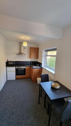 a kitchen with a table and a dining room at Cosy Studio · Easy City Access · Nottingham in Nottingham