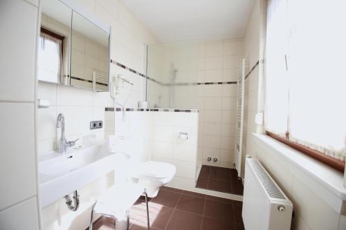 a white bathroom with a sink and a mirror at HOTEL ZILLNERs EINKEHR *** in Altheim