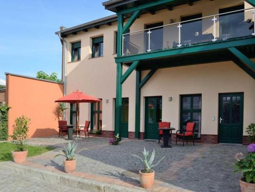a building with a patio with chairs and an umbrella at Malz in Lübbenau