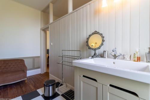 a bathroom with a sink and a mirror on the wall at L'orée du lac - Formule Chambres in Marcenay