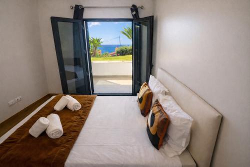 a bedroom with a bed with a view of the ocean at Paradisus guest house in Caniço