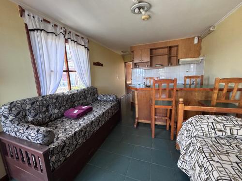 a living room with a couch and a kitchen at Apart Hotel Alem in Ushuaia