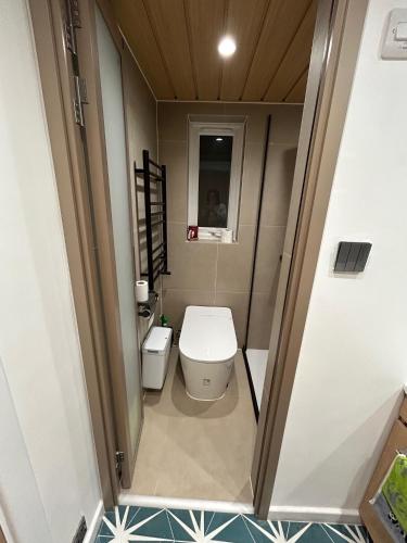 a small bathroom with a toilet and a sink at Baoyan Kingston - Guest House with 2 bedrooms with 1 toilet-washing room in Kingston upon Thames