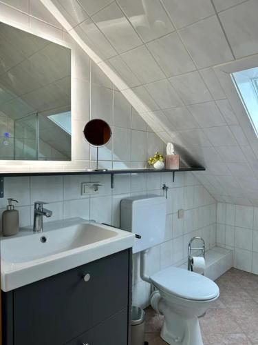ein Badezimmer mit Waschbecken, Toilette und Spiegel in der Unterkunft Schlierbachblick in Eschwege