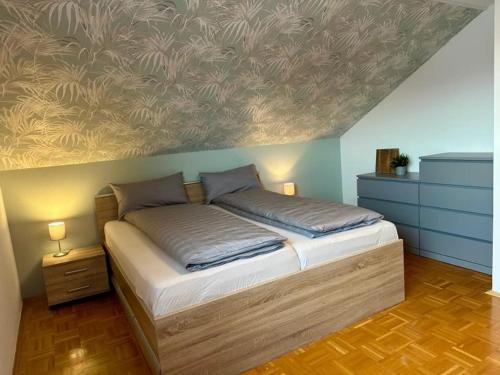 ein Schlafzimmer mit einem Bett und einem Gemälde an der Wand in der Unterkunft Schlierbachblick in Eschwege