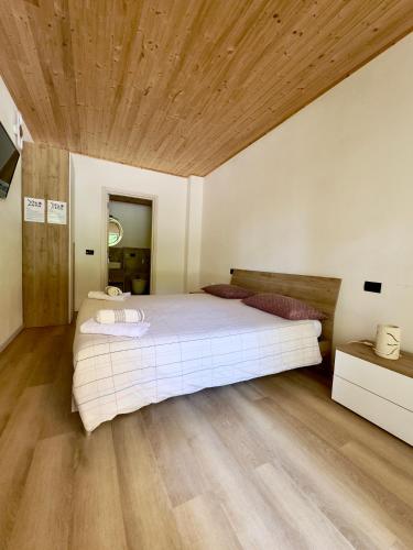a bedroom with a large white bed and wooden ceilings at Wild Side in Mollia
