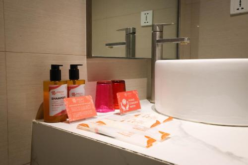 a bathroom sink with bottles ofodorizers on a counter at PROXY by The Oriental Albay in Legazpi