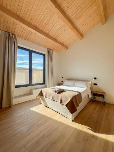 a bedroom with a large bed and a large window at Salon Suites in Tremp