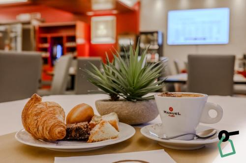 a table with a plate of bread and a cup of coffee at Hotiday Venezia Marco Polo in Campalto