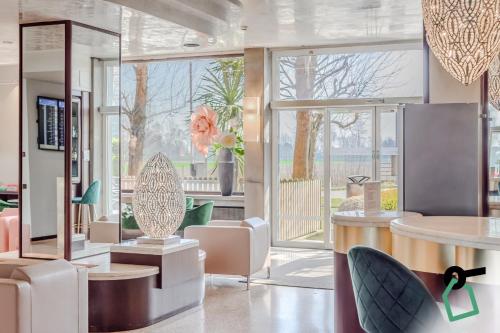 a lobby with chairs and tables and a large window at Hotiday Venezia Marco Polo in Campalto