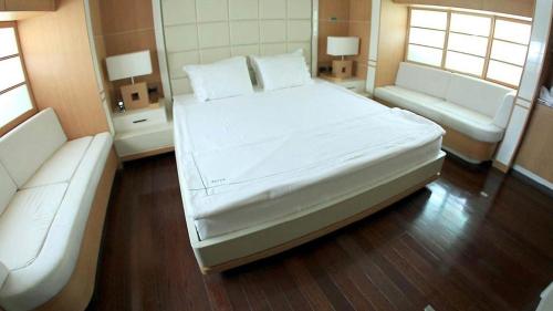 a bedroom with a large white bed and a couch at gold in Fethiye