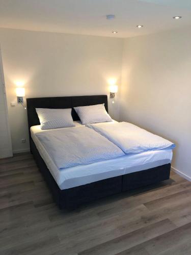 a bed with white sheets and pillows in a bedroom at Seaside-Amrum-18 in Norddorf