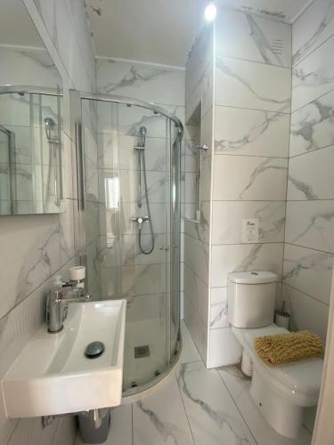 a bathroom with a shower and a toilet and a sink at Marija Block St Julian's Apartments in Is-Swieqi