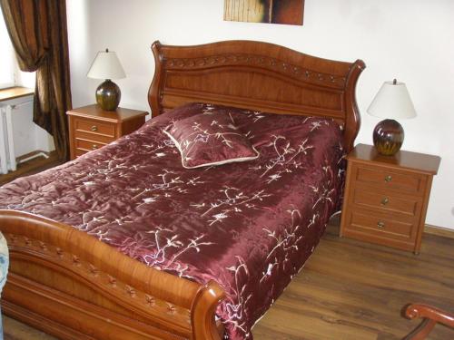 a bedroom with a wooden bed and two night stands at SHotels przy Restauracji Stodoła in Bartoszyce