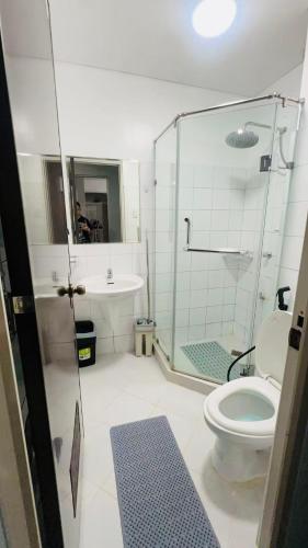 a bathroom with a shower and a toilet and a sink at Mezza Residences in Manila