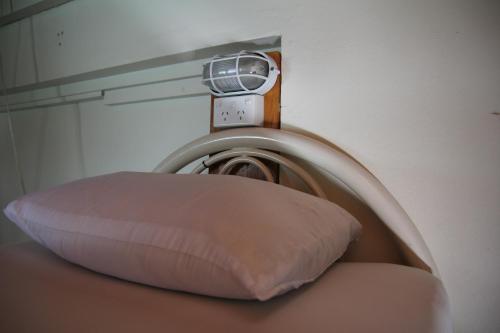 a pillow sitting on top of a wall with a clock at Bamboo Backpackers in Nadi