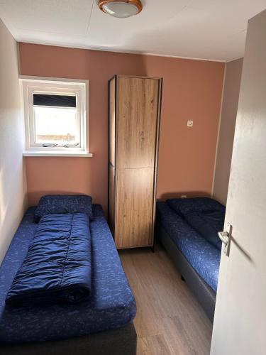a small room with two beds and a cabinet at Appartement Halfweg in Ballum