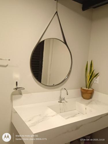 a bathroom with a sink and a mirror at Flat no Garden 2 in Rondonópolis