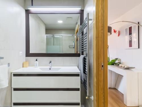 a bathroom with a sink and a mirror at Alojamientos Marte apartamento a pie de playa y garaje in Suances