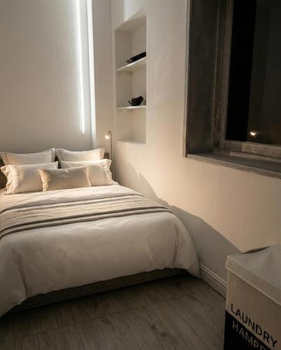 a small bedroom with a bed with a window at Mutamba Prime Stay in Luanda