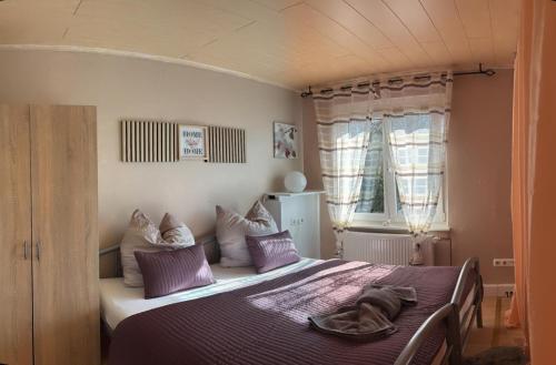 a bedroom with a large bed with purple pillows at Top location central in Rüsselsheim
