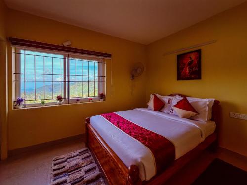 a bedroom with a bed and a window at Kodai Hillscape in Kodaikānāl