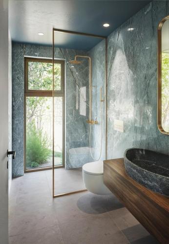 a bathroom with a tub and a toilet and a window at Veragi Boutique Villas in Lefkada