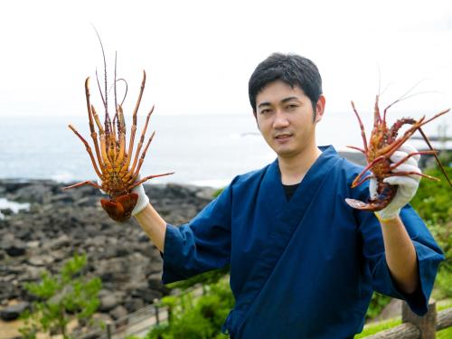 a man holding two lobsters in his hands at Iseebisou in Ibusuki