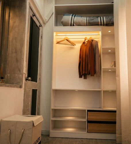 a walk in closet with an orange shirt in it at Mutamba Prime Stay in Luanda