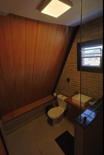 a small bathroom with a toilet and a sink at Chalés Vale da Luma in Cavalcante