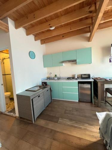 a kitchen with mint green cabinets and a wooden floor at Loft en Condesa in Mexico City