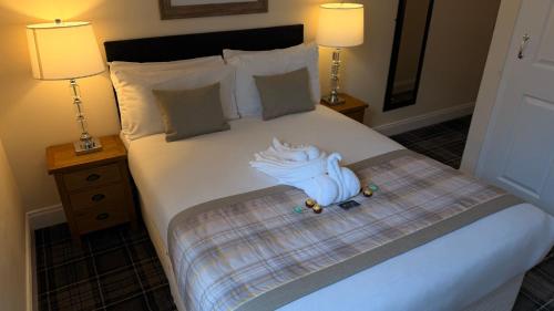 a bedroom with a bed with two lamps on it at The Waverley Guest House in Inverness