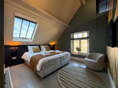 a bedroom with a bed and a chair and windows at B&B Louwi in Breugel