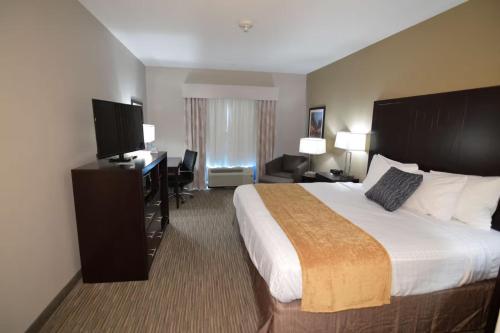 a hotel room with a large bed and a desk at New Roads River Hotel in New Roads