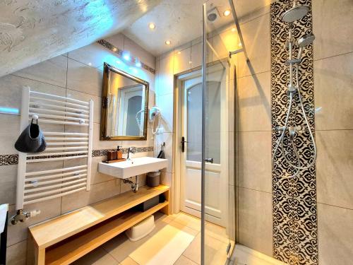 a bathroom with a sink and a shower at Apartament U Moniki, nad rzeką, jacuzzi w ogrodzie in Szaflary