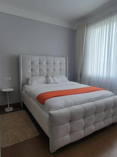 a large white bed in a room with a window at Haven Place 254-near JKIA,SGR with Self-Check in & Free Parking in Nairobi