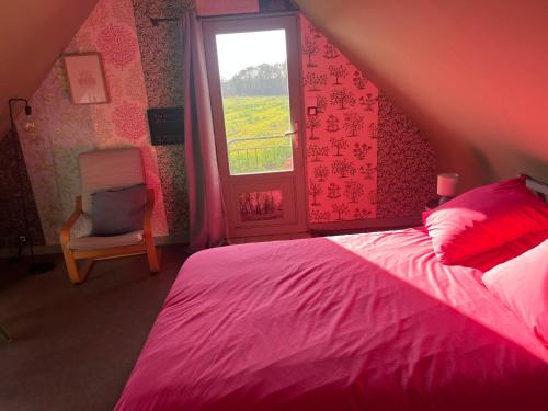 a bedroom with a pink bed and a window at Escapade de charme à Questembert in Questembert