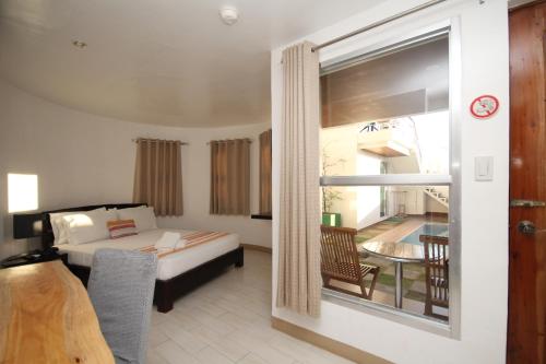 a hotel room with a bed and a balcony at Bluewaves Westcliff Villa in Boracay