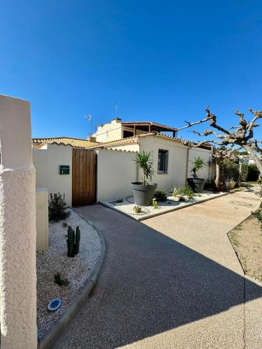 a house with a driveway in front of it at MAISON LEUCATINE - Classée 4 étoiles ! BBQ & Terrasse Privée - Climarisation & Parking privé - Séjour PROCHE PLAGE et IDEAL Famille - OFFRE SPECIALE - in Leucate-Plage