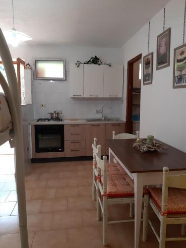 a kitchen with a table and a stove top oven at Appartamento Tavernetta Corallo Rosso in Isca Marina
