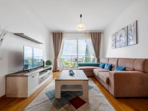 a living room with a couch and a tv at Tamariz Flat in Santa Cruz