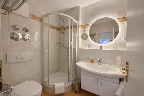 a bathroom with a shower and a toilet and a sink at Tivoli Apartments in Bad Reichenhall