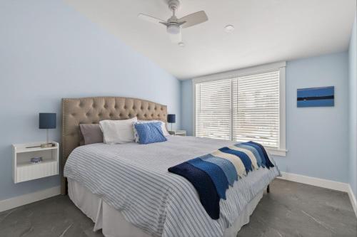 a bedroom with a large bed with blue and white sheets at Modern Waterfront Apt with Bay Views in Falmouth