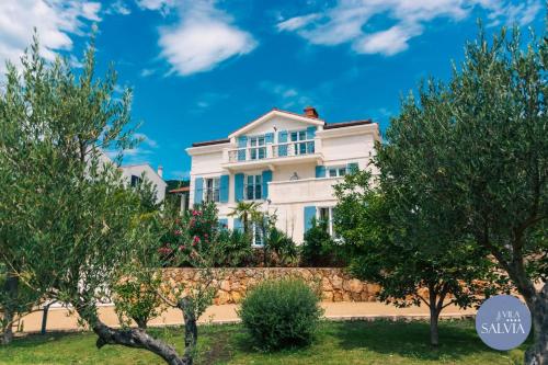 a white house with trees in front of it at Rooms Salvia in Cres